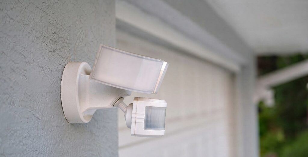 Technicien installant une sirène d'alarme extérieure avec flash lumineux sur la façade en brique d'un bâtiment commercial belge. Technicien installant une sirène d'alarme extérieure avec flash lumineux sur la façade en brique d'un bâtiment commercial belge.